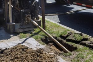 Trenchless pipe lining equipment in use for plumbing repairs, showcasing a digging site with exposed soil and machinery, relevant to plumbing solutions in Broward County, Florida.