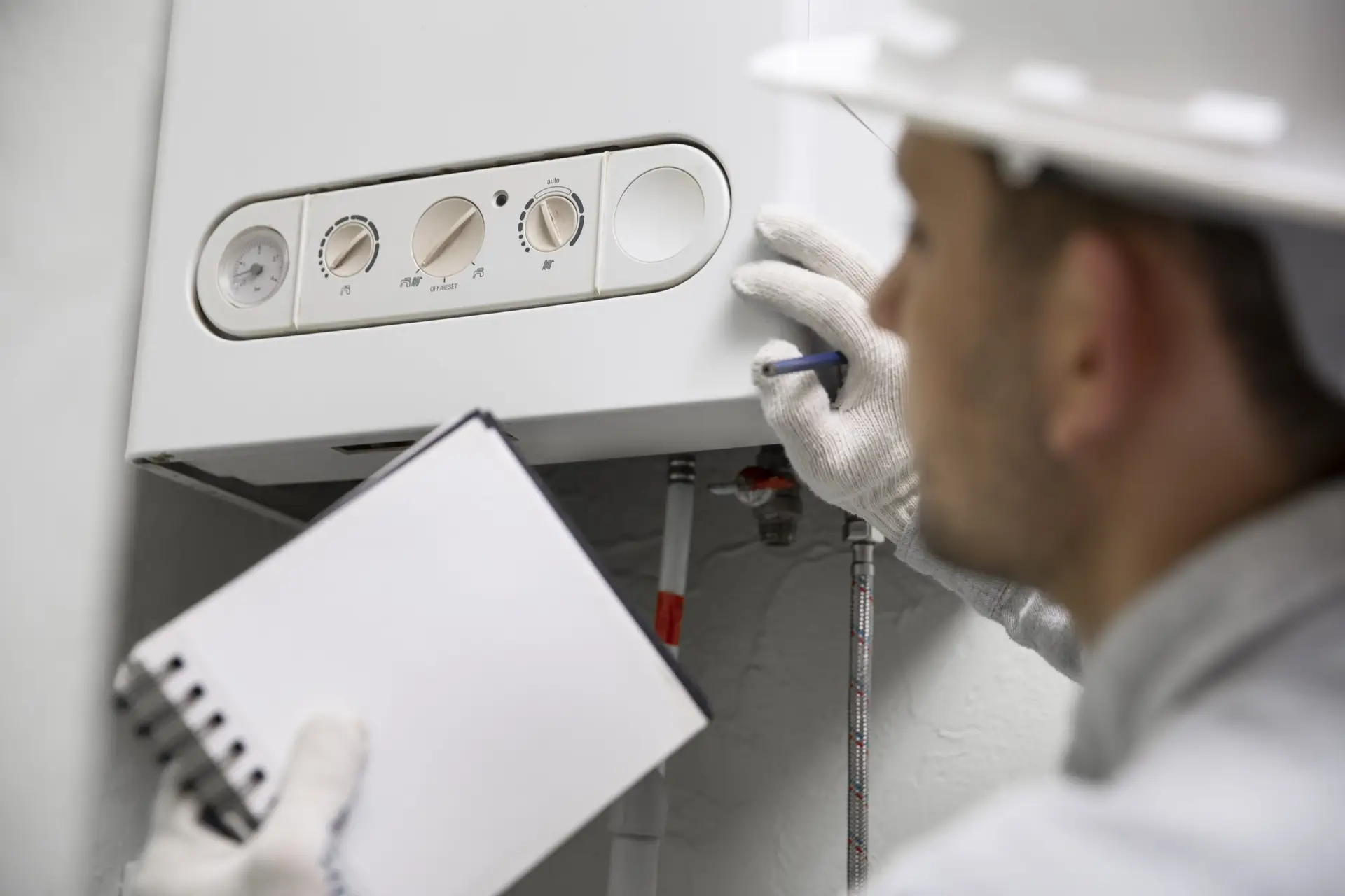 Plumber repairing water heater in Coral Springs, FL, with notepad and tools.